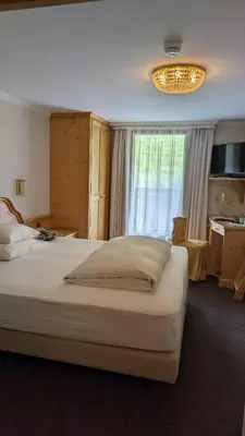 a hotel room with two beds and a table at Hotel Evaldo in Arabba