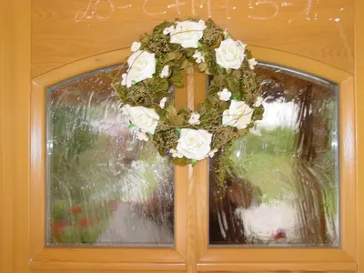 a wreath on a window with white roses at Ciasa Rudiferia Appartamenti in Alta Badia in Badia