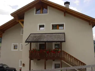 a house with a balcony with flowers on it at Ciasa Rudiferia Appartamenti in Alta Badia in Badia