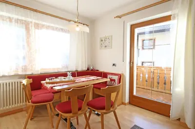 a dining room with a table and chairs and a window at Ciasa Rudiferia Appartamenti in Alta Badia in Badia