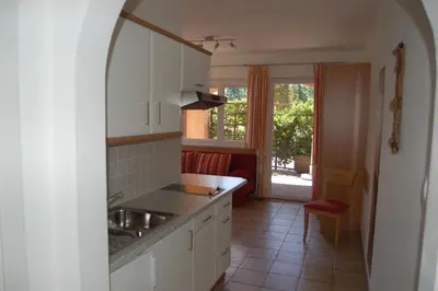 a kitchen with white cabinets and a sink and a window at Appartementhaus Am Waalweg in Rifiano