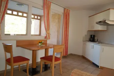 a kitchen with a table and two chairs and a window at Appartementhaus Am Waalweg in Rifiano