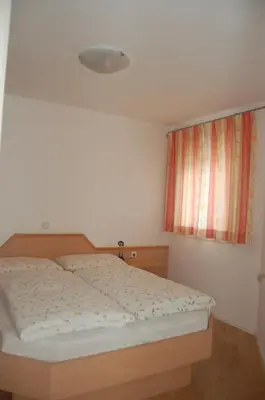 a bedroom with a bed and a window at Appartementhaus Am Waalweg in Rifiano