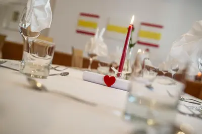 a table with glasses and a red heart on it at Pension Prack in Brunico