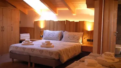 a bedroom with a large bed with towels on it at BB le Fontanelle in Carano