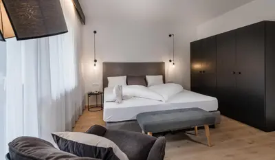 a bedroom with a large white bed and a couch at Hotel Wilma in Nalles