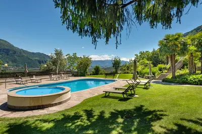 a swimming pool in a yard with chairs around it at Hotel Wilma in Nalles