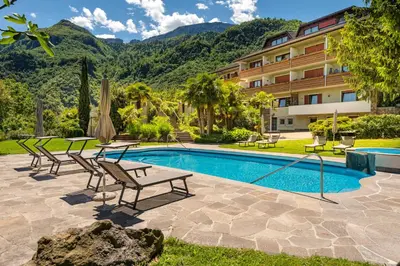 a swimming pool with chairs and a hotel at Hotel Wilma in Nalles