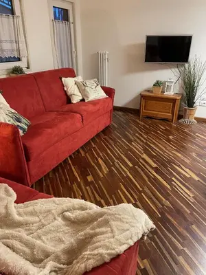 a living room with a red couch and a flat screen tv at Apartments Casa Metz in Santa Cristina in Val Gardena