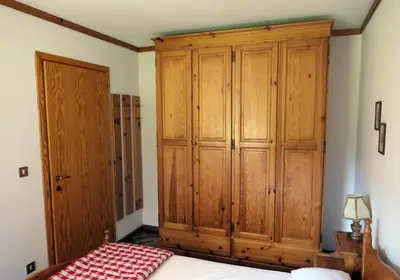a bedroom with a large wooden cabinet and a bed at Apartments Casa Metz in Santa Cristina in Val Gardena