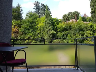 a balcony with a table and chairs and trees at Nadia's Home in Merano