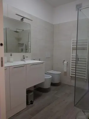 a bathroom with a sink and a toilet and a mirror at Nadia's Home in Merano