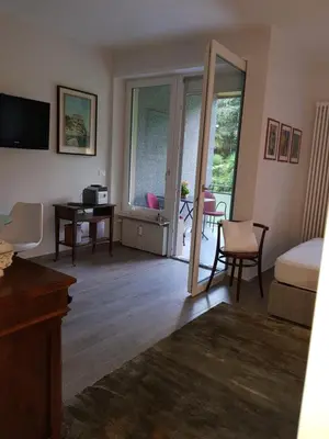 a bedroom with a bed and a desk and a mirror at Nadia's Home in Merano