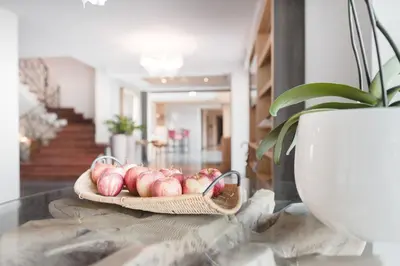 a basket of apples on a table with a potted plant at Hotel Tiefenbrunn Gardensuites & Breakfast in Lana