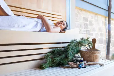 a man laying on a bed with a christmas tree at Hotel Tiefenbrunn Gardensuites & Breakfast in Lana