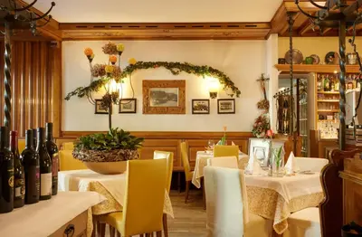 a restaurant with tables and chairs and a mirror at Parkhotel Post in Chiusa