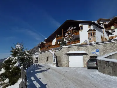 a building with a car parked in the snow at Residence Sovara in Santa Cristina in Val Gardena