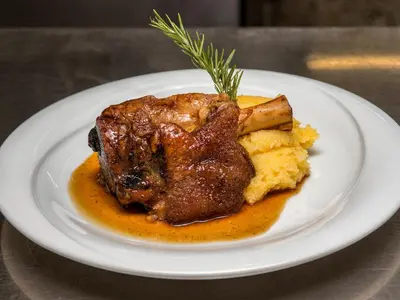 a plate of food with a piece of meat and mashed potatoes at Albergo Panorama in Panchia