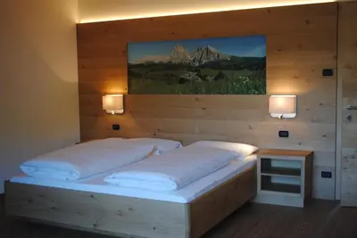 a bedroom with a bed with a painting on the wall at Hotel Garni Walter in Ortisei
