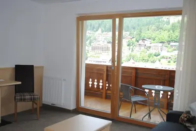 a room with a balcony with a table and chairs at Hotel Garni Walter in Ortisei