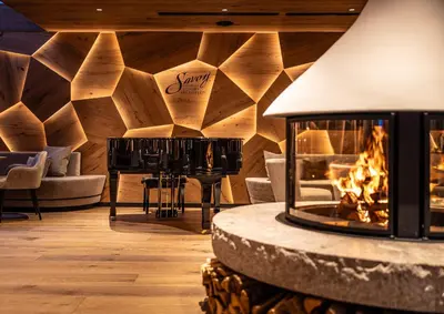 a woman standing on top of a ski slope at Savoy Dolomites Luxury & Spa Hotel in Selva di Val Gardena
