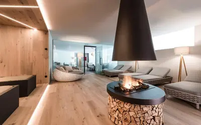 a living room with a fireplace in the middle of a room at Hotel Seeber in Racines