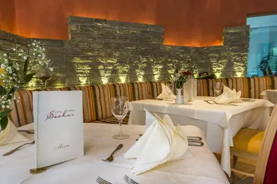 two tables in a restaurant with white tableclothsurrencyangering at Hotel Seeber in Racines
