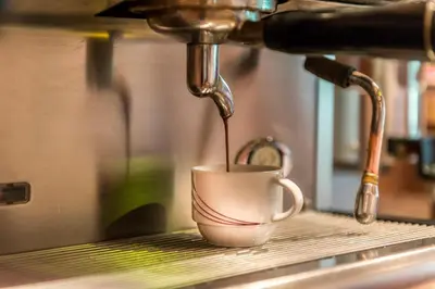 a coffee maker pours coffee into a coffee cup at Hotel Seeber in Racines