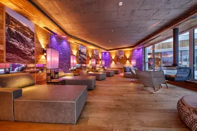 a lobby with couches and tables and purple walls at Hotel Plunhof in Ridanna