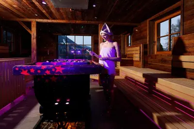 a woman in a purple dress standing in front of a bar at Hotel Plunhof in Ridanna