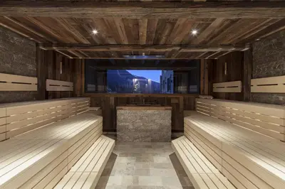 a sauna with wood paneling and a large window at Hotel Plunhof in Ridanna