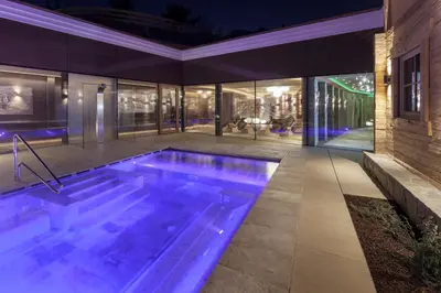 an indoor swimming pool in a house at night at Hotel Plunhof in Ridanna