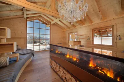 a living room with a fireplace in a log cabin at Hotel Plunhof in Ridanna