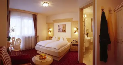 a hotel room with a bed and a bathroom at B&B Appartments Cudlea in Selva di Val Gardena