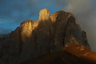 a mountain in the middle of a cloudy sky at B&B Appartments Cudlea in Selva di Val Gardena