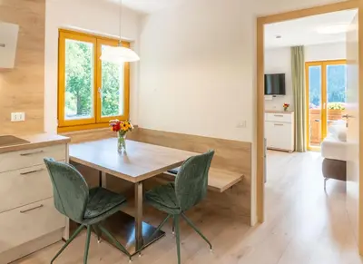 a kitchen and dining room with a table and chairs at Residence Töglhof in Funes