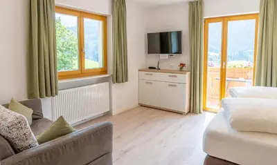 a living room with a couch and a tv at Residence Töglhof in Funes