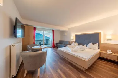 a hotel room with a bed and a living room at Hotel Meinhardt in Schenna
