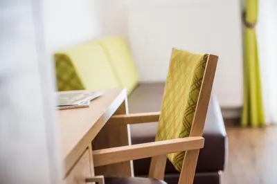 a wooden table with two chairs and a desk with at Hotel Meinhardt in Schenna