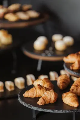 a bunch of croissants and other pastries on plates at Luxury B&B August in Ortisei
