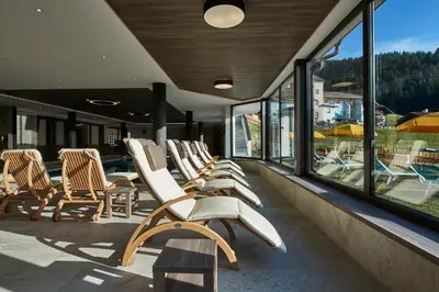 a row of chairs sitting on a balcony with windows at Residence La Selva in Selva di Val Gardena