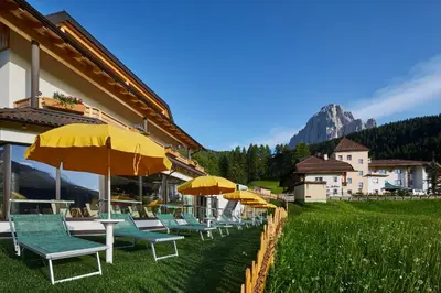 a row of tables and chairs with umbrellas at Residence La Selva in Selva di Val Gardena
