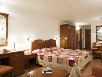 a bedroom with a bed and a table and a desk at Residence Villa Gran Baita in Selva di Val Gardena
