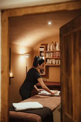 a woman standing between two beds in a room at Hotel Alpenrose in Arabba