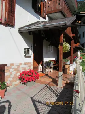 a patio with awning and flowers on a building at Ciesa Dei Maestri in Sottoguda