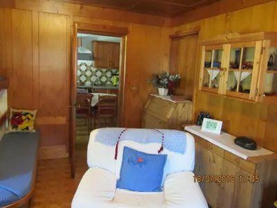 a living room with a white couch and a kitchen at Ciesa Dei Maestri in Sottoguda
