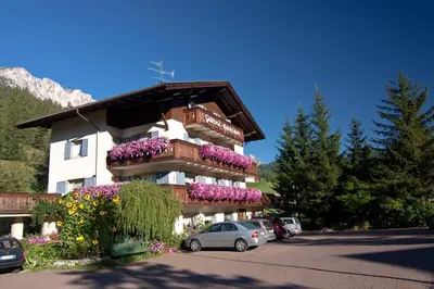 a building with flowers on the side of it at Pension Enzian in Badia