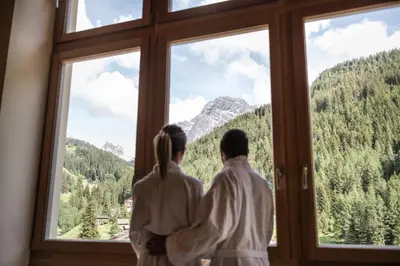 a couple looking out of a window at the mountains at Hotel Alcialc in La Valle