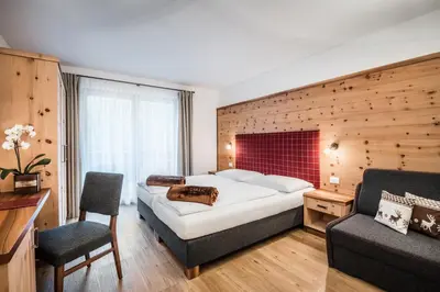 a hotel room with a bed and a chair at Hotel Alcialc in La Valle