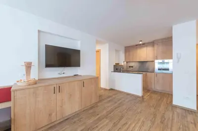 a large kitchen with wooden cabinets and a flat screen tv at Residence Lersc in Badia